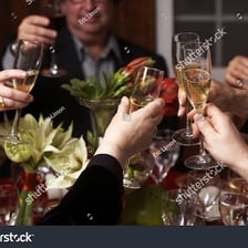 People raising glasses during a celebratory toast