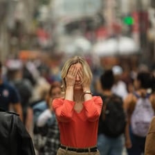 A person appearing vulnerable in a busy public setting.