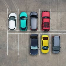 A car being positioned in an open parking space