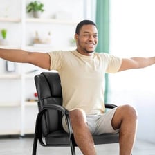 A person gesturing toward an available chair.