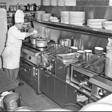 A cook preparing food in a classic diner kitchen.