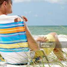 A person relaxing in a chair with their feet kicked up.