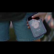 A person smiling while saying goodbye during a phone call