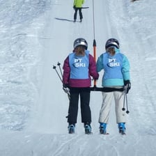 A skier being towed uphill by a T-bar lift.
