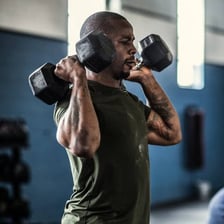 A person performing repeated dumbbell exercises