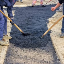 A road crew applying asphalt during road repair