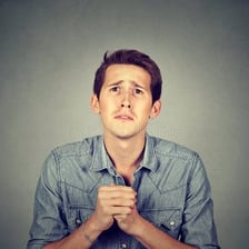 A person reacting with mild frustration to a mistake