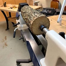A woodworker shaping a piece of wood on a lathe