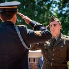 A uniformed soldier giving a formal salute.