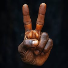 A hand held up with two fingers extended in a peace sign.