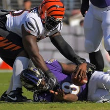 A defensive tackle tackles a quarterback during an NFL game.