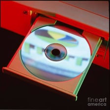 A compact disc labeled CD-ROM beside a computer drive