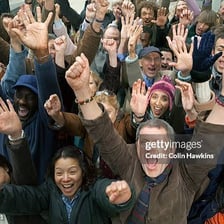 A cheering crowd celebrating with raised arms.