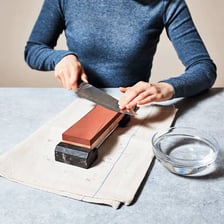 A person sharpening a knife with a honing stone