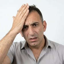 A person reacting to a mistake with a puzzled expression.