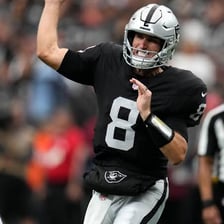 An NFL quarterback throwing a football during a game.