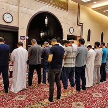 Imam leading worshippers in prayer inside a mosque