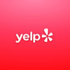 The Yelp logo displayed on a smartphone showing business reviews.