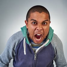 An intensely angry person with a tense, frustrated expression.