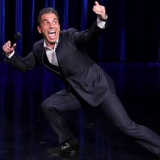 A comedian performing a comic bit onstage.