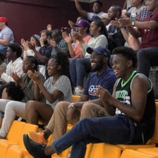 A sports fan seated in stadium bleachers.
