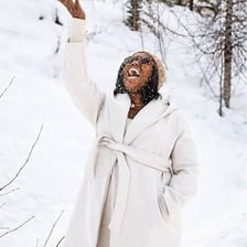 A person wearing a winter parka in a snowy mountain setting