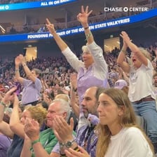 A large crowd making loud cheers in a stadium.