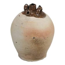 An antique ceramic ewer with a handle and pouring spout.