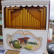 A vintage calliope, also known as a steam organ, with rows of whistles.