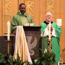 A priest speaking with someone in a church