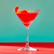 A pink Cosmopolitan cocktail served in a stemmed martini glass.