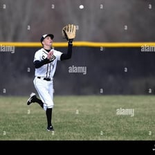 A baseball player catching a fly ball during fielding practice.