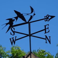 A weather vane mounted on a rooftop.