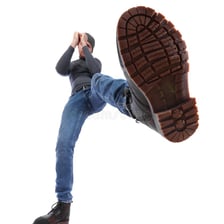 A boot pressing forcefully onto the ground