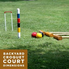 A croquet court set up on a grassy yard.