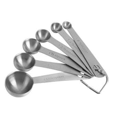 Six teaspoons arranged beside a liquid measuring container