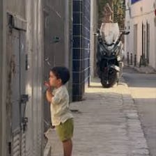 A young boy in a Barcelona streetscape.
