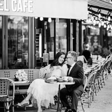 A romantic couple seated at a café in Paris.