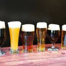 Several glasses of ale arranged in a line