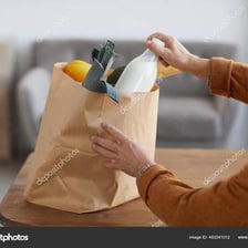 A person taking groceries out of reusable shopping bags.