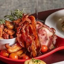 A paycheck and strips of bacon displayed together