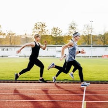 A runner moving quickly around an outdoor track.