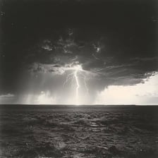 Lightning and dark storm clouds over a landscape