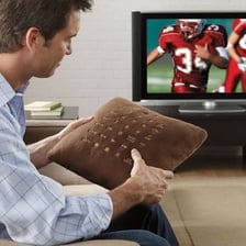 A television remote resting on a sofa cushion