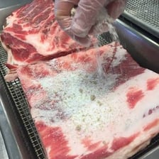Meat being preserved through a traditional curing process.