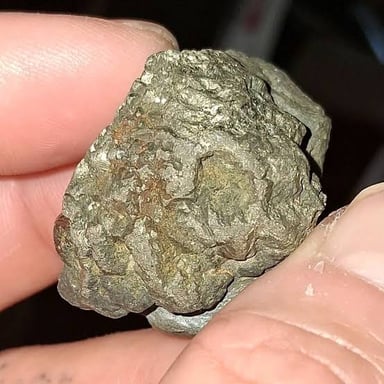 A gold-colored electrum specimen, an alloy composed chiefly of gold and silver.