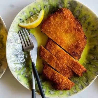 A breaded cutlet served on a plate.