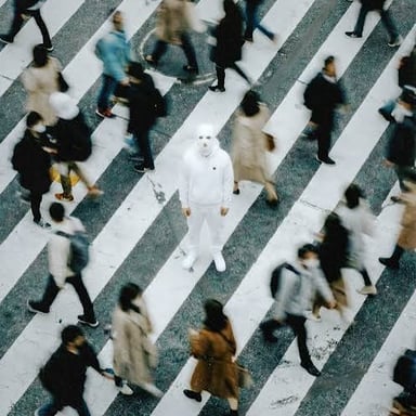 A person walking among pedestrians in a busy city crowd.