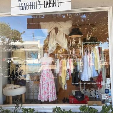 A small retail boutique with clothing displayed in its window.
