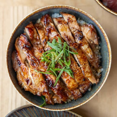 A plate of grilled chicken pieces coated in glossy teriyaki sauce.